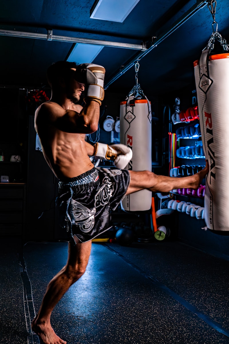 Man practicing muay thai kickboxing with a heavy bag.
