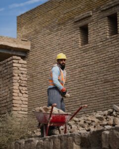 a man standing next to a pile of rubble